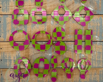 May include: A collection of handmade earrings in various shapes, including squares, circles, and oblongs. The earrings feature a checkerboard pattern in bright green and magenta. The word "aya" is visible in a cursive font.