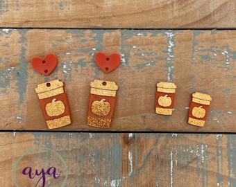 May include: A set of five fall-themed acrylic charms. Two red heart charms, two orange coffee cup charms with a pumpkin design, and one smaller orange pumpkin charm.