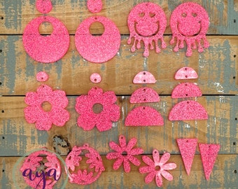 May include: Assortment of pink glitter earrings in various shapes, including circles, flowers, smiley faces, and triangles.