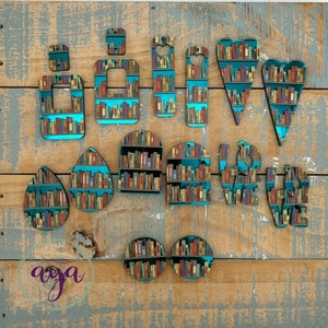 May include: Assortment of teal blue mirror acrylic shapes with a book shelf design. The shapes include hearts, ovals, circles, and rectangles.