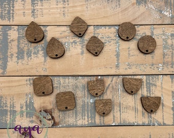 May include: Assortment of wooden shapes with holes for hanging. The shapes include circles, squares, diamonds, teardrops, and half-circles. The wood is a dark brown colour.