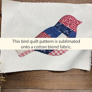 May include: A bird quilt pattern sublimated onto a cotton blend fabric. The bird design features red, white, and blue patchwork, with a mix of patterns including polka dots and gingham. The text on the image reads: "This bird quilt pattern is sublimated onto a cotton blend fabric."