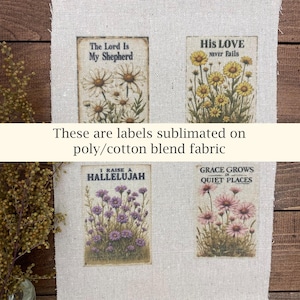 May include: Four rectangular labels with floral illustrations and inspirational text are displayed on a beige fabric. The labels read: "The Lord Is My Shepherd," "His Love Never Fails," "I Raise a Hallelujah," and "Grace Grows in Quiet Places."