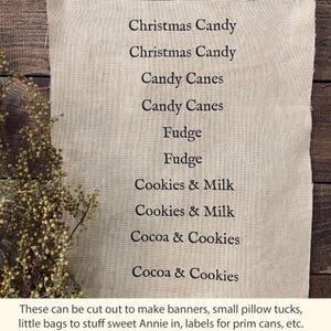 May include: A beige fabric with printed text listing Christmas Candy, Candy Canes, Fudge, Cookies & Milk, and Cocoa & Cookies. The text is repeated. The fabric is next to dried plants. The text at the bottom says these can be cut out to make banners, small pillow tucks, etc.