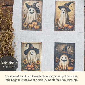 May include: A fabric sheet featuring four rectangular prints of ghosts wearing witch hats, surrounded by sunflowers and pumpkins. Each label measures 4 inches by 2.67 inches. The ghosts have smiling faces and are set against a light beige background.