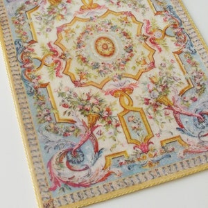 May include: A vintage-style floral patterned rug with a blue and yellow border. The rug has a central medallion with a floral design and a gold border.