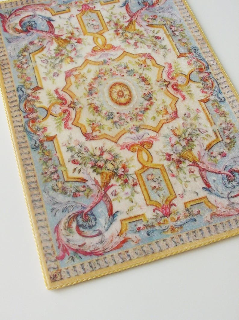 May include: A vintage-style floral patterned rug with a blue and yellow border. The rug has a central medallion with a floral design and a gold border.
