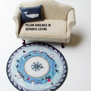 May include: A round blue and white nautical rug with a compass design and a white whale on a blue pillow. The text "PILLOW AVAILABLE IN SEPARATE LISTING" is on the couch.