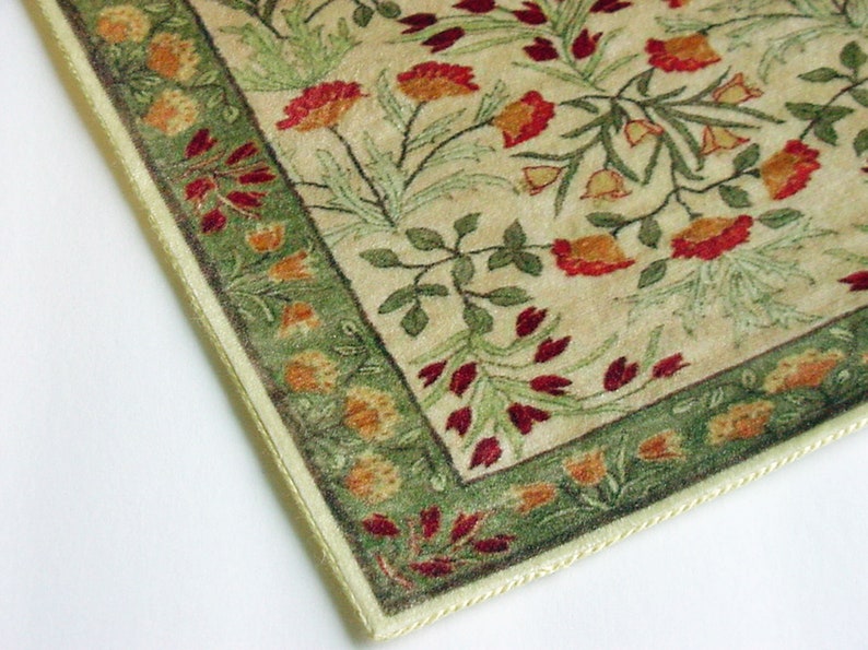 Puede incluir: Una alfombra beige con un patr&oacute;n floral verde y rojo. La alfombra tiene un borde de color crema con flecos.