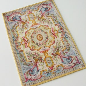 May include: A vintage-style rug with a floral and scroll design in shades of pink, blue, yellow, and green. The rug has a gold border.
