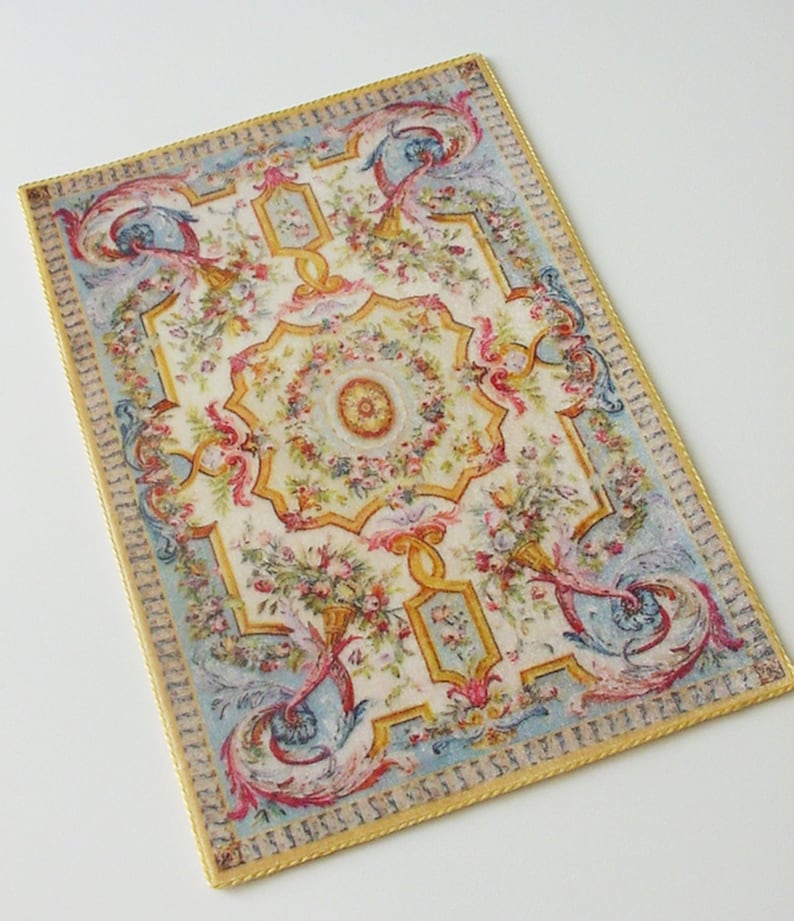 May include: A vintage-style rug with a floral and scroll design in shades of pink, blue, yellow, and green. The rug has a gold border.