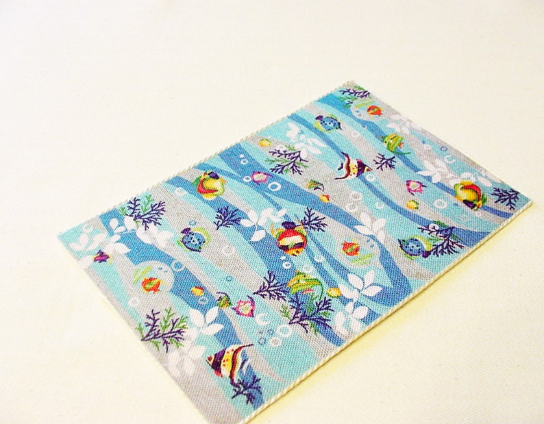 May include: A blue and grey rug with a pattern of colourful fish, bubbles, and seaweed. The rug has a white border.