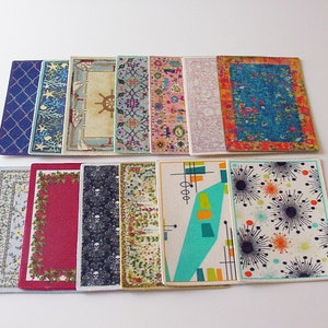 May include: A collection of 12 miniature rugs in various colors and patterns, including floral, geometric, and abstract designs. The rugs are made of fabric and are approximately 3 inches wide and 4 inches long.