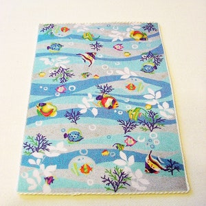 May include: A blue and grey bath mat with a white border. The mat features a repeating pattern of colourful fish, bubbles, and seaweed.