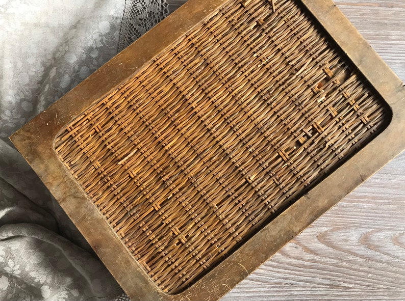 Puede incluir: Una bandeja de madera con un inserto de mimbre tejido. La bandeja tiene un marco de madera marr&oacute;n oscuro y el mimbre es de color marr&oacute;n claro.