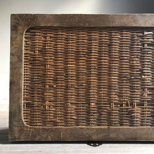 Puede incluir: Una caja de madera con un panel de mimbre tejido en la parte delantera. La caja tiene un acabado marr&oacute;n oscuro y un dise&ntilde;o sencillo.