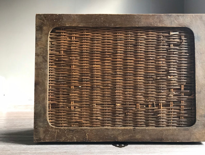 Puede incluir: Una caja de madera con un panel de mimbre tejido en la parte delantera. La caja tiene un acabado marr&oacute;n oscuro y un dise&ntilde;o sencillo.