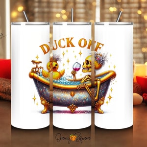 May include: White tumbler featuring a gold design of a skeleton and a duck in a bathtub. The text "DUCK OFF" is written in gold letters on the tumbler.