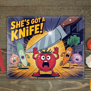 Puede incluir: Una tabla de cortar rectangular con el texto "SHE'S GOT A KNIFE!" presenta verduras de dibujos animados huyendo de un cuchillo grande. También se ve un cuchillo con mango rojo y tomates frescos.