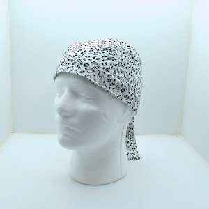 May include: White surgical scrub hat with a black musical note pattern.