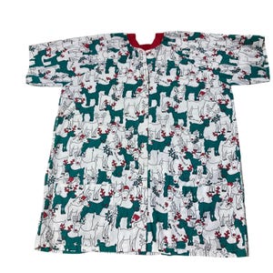 May include: White Christmas-themed button-up shirt with a red collar. The shirt is covered in a pattern of green reindeer wearing Santa hats and holding gifts. The reindeer are set against a white background.