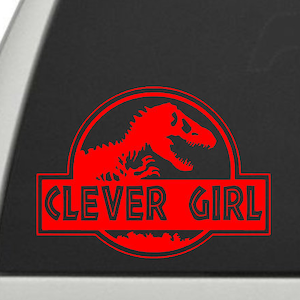 May include: Red car window sticker with a red dinosaur silhouette inside a circle and the text "Clever Girl".