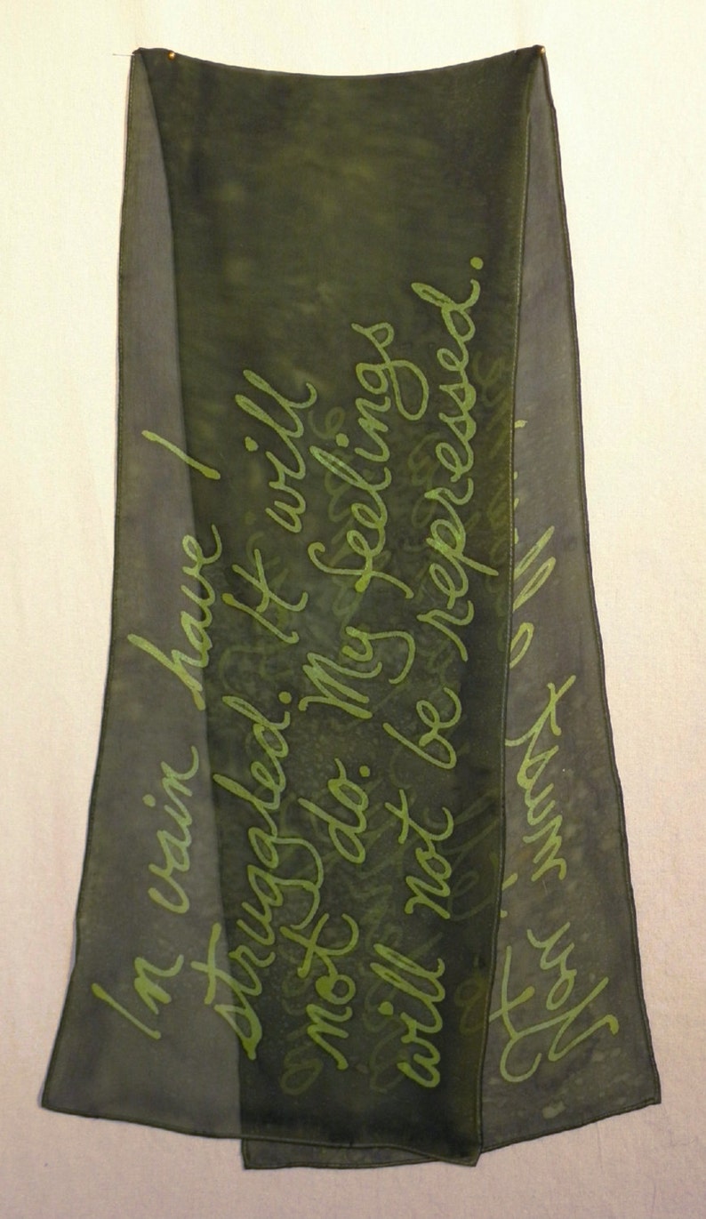 Puede incluir: Una bufanda de seda verde oscuro con un mensaje escrito a mano en tinta verde que dice "En vano he luchado. No servir&aacute; de nada. Mis sentimientos no ser&aacute;n reprimidos."