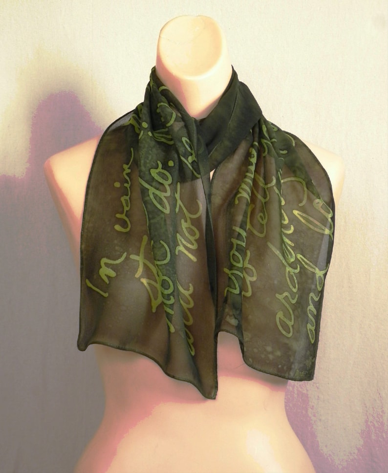 Puede incluir: Una bufanda de gasa verde oscuro con una inscripci&oacute;n verde claro que dice "No soy vanidosa, simplemente no quiero parecer ordinaria."