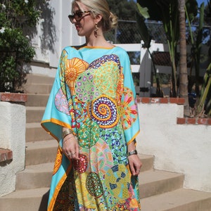 Puede incluir: Una larga kaftán turquesa fluida con un estampado geométrico colorido. La kaftán tiene un escote amplio y fluido y un ajuste holgado y cómodo. El estampado presenta una variedad de formas y colores, incluyendo círculos, cuadrados y triángulos. La kaftán es perfecta para un día de verano o una noche fuera.