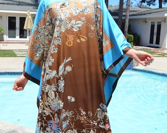 May include: A brown and blue floral print kaftan with a blue trim. The kaftan is worn by a person standing by a swimming pool.