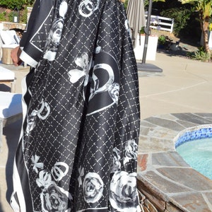 May include: Black and white patterned kimono with a white trim. The pattern features a quilted design with roses and a large interlocking 'C' logo.