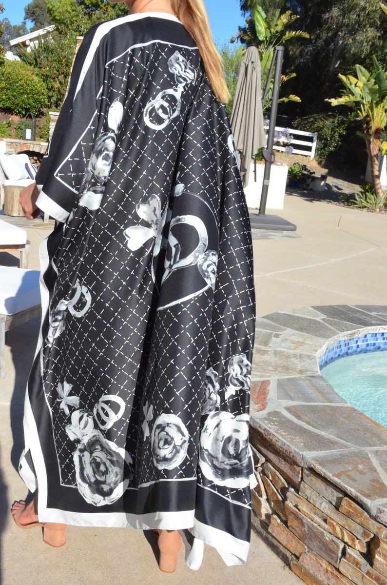 May include: Black and white patterned kimono with a white trim. The pattern features a quilted design with roses and a large interlocking 'C' logo.