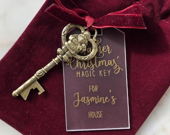 May include: A burgundy velvet pouch with a decorative antique brass key. The key is attached to a tag that reads "Father Christmas' Magic Key" and "For Jasmine's House". The key has a Santa Claus design.