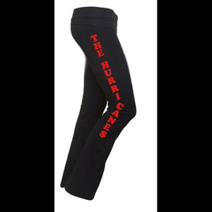 Op de afbeelding: Zwarte yogabroek met de tekst "The Hurricanes" in rood langs de zijkant.