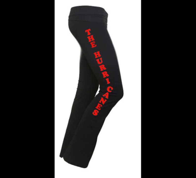 Op de afbeelding: Zwarte yogabroek met de tekst "The Hurricanes" in rood langs de zijkant.
