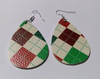 May include: A pair of teardrop-shaped earrings with a festive argyle pattern. The earrings feature a cream-colored background with red, green, and brown diamond shapes. The earrings have silver-colored ear wires.