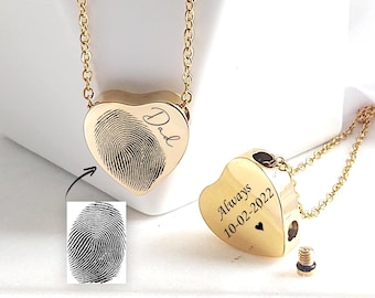 May include: Gold-colored heart-shaped pendant necklace. The pendant features a fingerprint design and the word "Dad". The necklace includes a chain and a small screw-top compartment. The back of the pendant is engraved with the word "Always" and the date "10-02-2022".