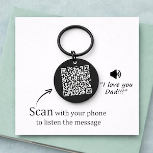 Peut inclure: Un porte-clés rond noir avec un code QR et un anneau noir. Le texte "Scannez avec votre téléphone pour écouter le message" et "I love you Dad!!!" sont également présents.
