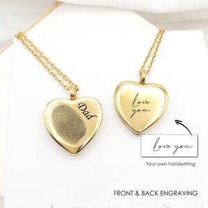 May include: Two gold-toned heart-shaped pendants on delicate chains. One pendant features an engraved fingerprint and the word Dad. The other pendant displays the engraved text love you. A small box shows the text love you and Your own handwriting.
