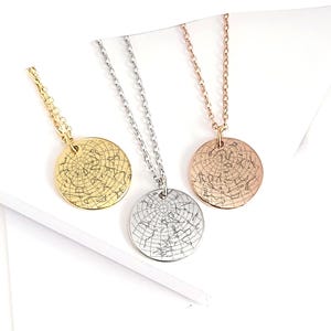 May include: Three circular pendant necklaces featuring engraved celestial star map designs. The set includes one gold-toned, one silver-toned, and one rose gold-toned metal pendant, each suspended from a matching delicate link chain necklace.