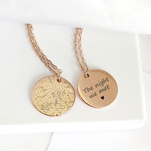 May include: Two rose gold-toned circular pendant necklaces with delicate chains. One pendant features an engraved celestial star map with grid lines. The other pendant is engraved with the black text "The night we met" and a small heart symbol.