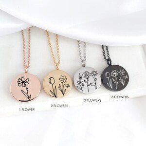 May include: Four round pendant necklaces with floral designs. The pendants are rose gold, gold, silver, and black. Each pendant has a different floral design with the number of flowers labeled below each pendant.