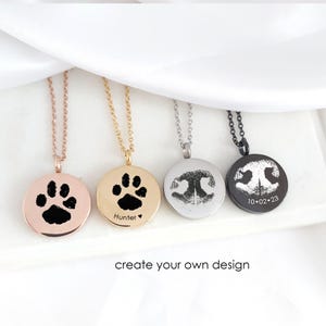 May include: Four circular pendant necklaces in rose gold, gold, silver, and black tones. Each pendant features a custom black engraved design, including animal paw prints and nose prints. One pendant includes the text Hunter and a heart, another 10.02.23.