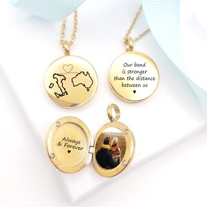 May include: Three gold-toned circular pendants on chains. One shows a map of Italy and Australia with a heart, another reads "Our bond is stronger than the distance between us," and the third is an open locket with "Always & Forever" and a photo.