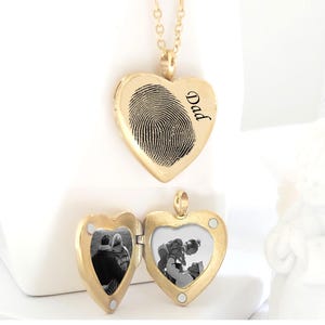 Gold heart-shaped locket necklace with fingerprint and 'Dad' engraved on one side. The other side is a hinged locket that opens to reveal a photo of two people.  The necklace is non-tarnish and available in gold, silver, and rose gold.