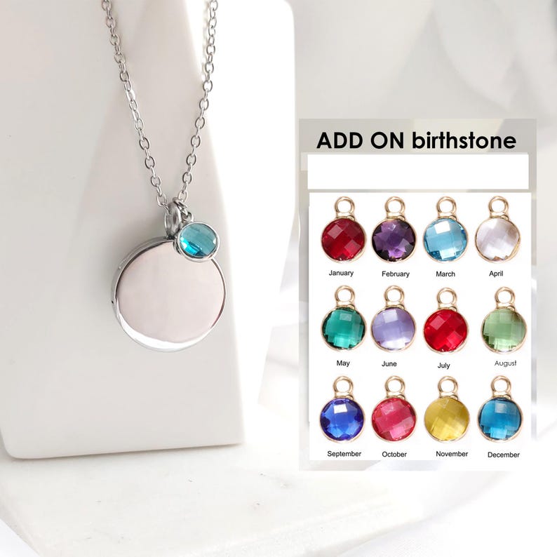May include: A silver-toned necklace featuring a circular pendant and a small, round, blue birthstone charm. Beside it, a chart titled ADD ON birthstone displays twelve distinct colored crystal charms labeled by month from January to December.