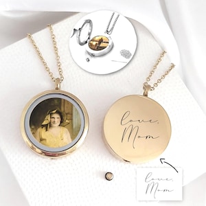 Peut inclure: Un collier médaillon circulaire doré présentant une photographie d'une personne portant une robe et un chapeau jaunes. Le verso est gravé du texte manuscrit "love, Mom". Un petit encart circulaire montre le médaillon ouvert avec une photo.