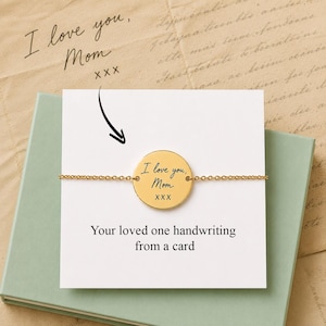 Peut inclure: Un bracelet avec un pendentif circulaire doré portant l'inscription gravée en noir "I love you, Mom XXX". Le bracelet est présenté sur une carte blanche avec le texte "Your loved one handwriting from a card" et une flèche noire pointant vers le pendentif.