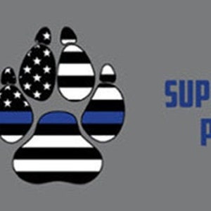 May include: A banner with six paw prints in a thin blue line design. The text on the banner reads "Support the paws that protect our laws".