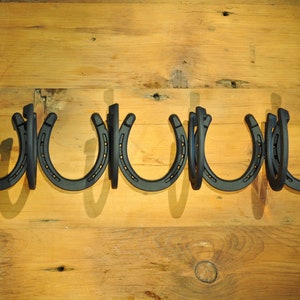 4 Coat Wall Mounted Horseshoe Coat Rack.  23 1/4L x 4 1/2W x 4 3/4H.